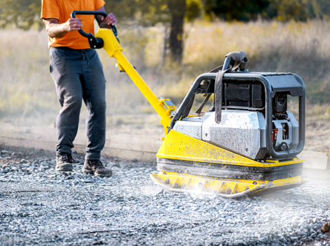Person using heavy vibrating machinery to pack down tarmac