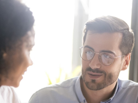 Man and woman having a conversation in front of a brightly lit window