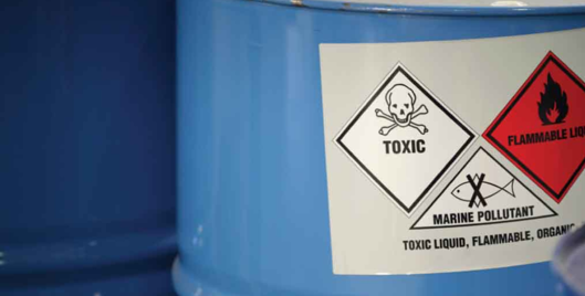 Blue vat of chemicals labelled toxic, flammable liquid and marine pollutant