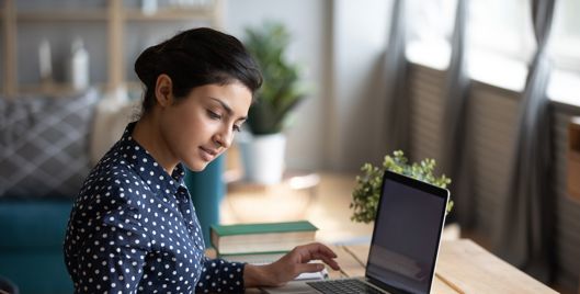 professional lady reading and using a laptop at a desk