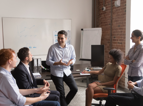 Group of people sat around in an office having a positive discussion